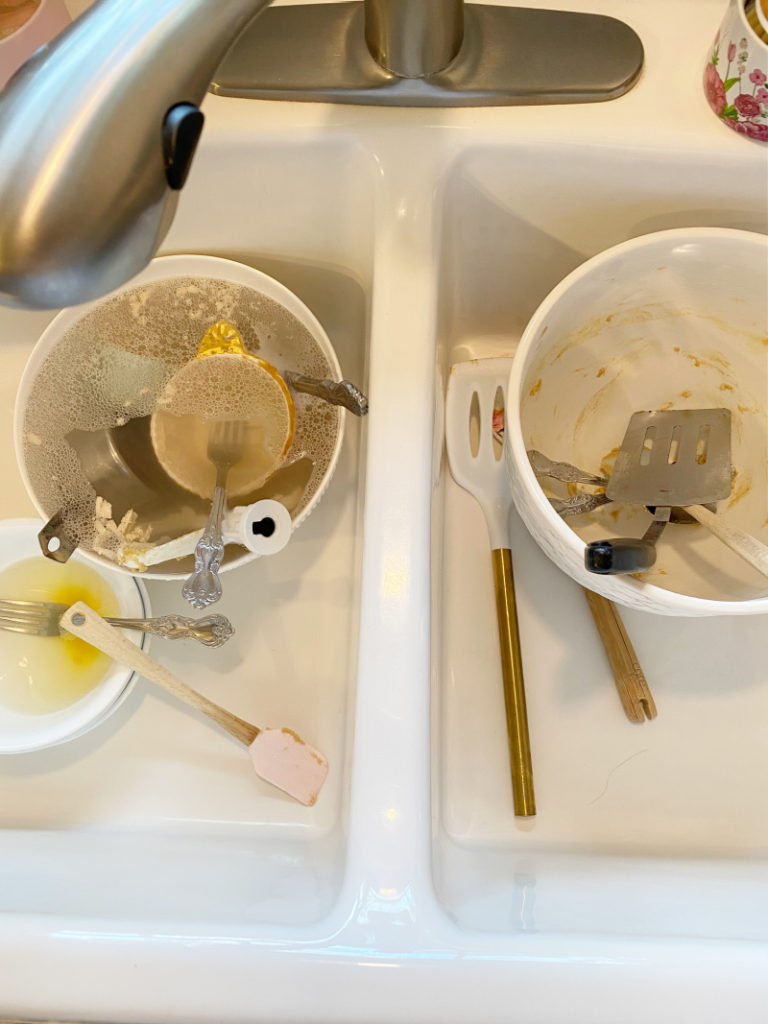 Dirty dishes from cookie making in white porcelain sink