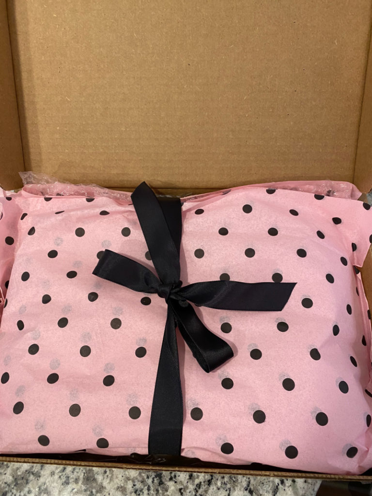 Cookies in package with pink polka dot wrap and a black bow ready to mail
