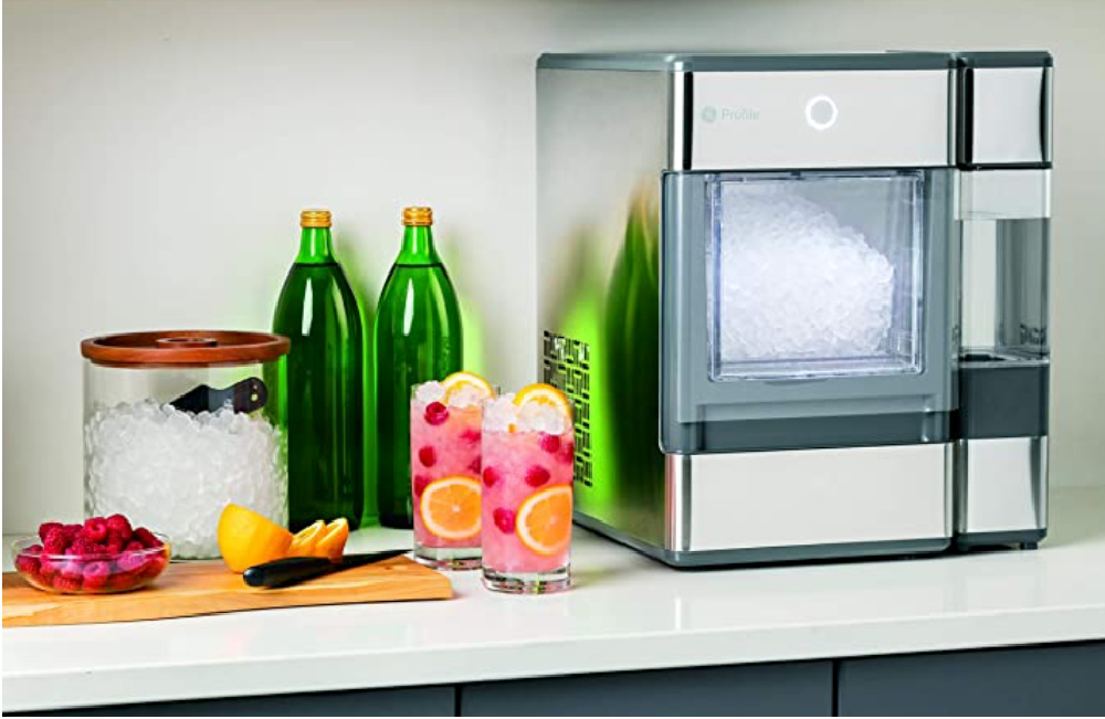 Pebble Ice Maker In Kitchen with two pink drinks with ice and orange and raspberries and two green water bottles