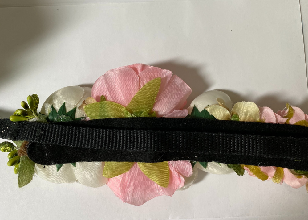 black dog collar laying on the band of the flowers