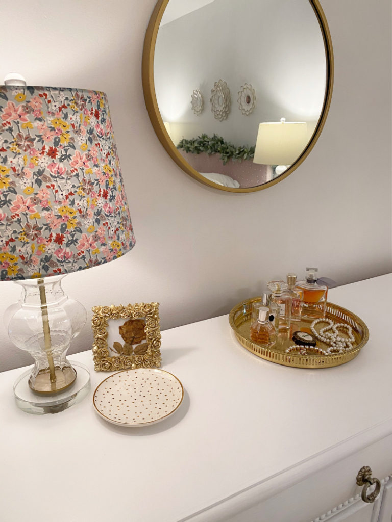 White painted dresser with floral lamp, gold framed yellow pressed rose and gold tray with elegant perfumes and jewelry