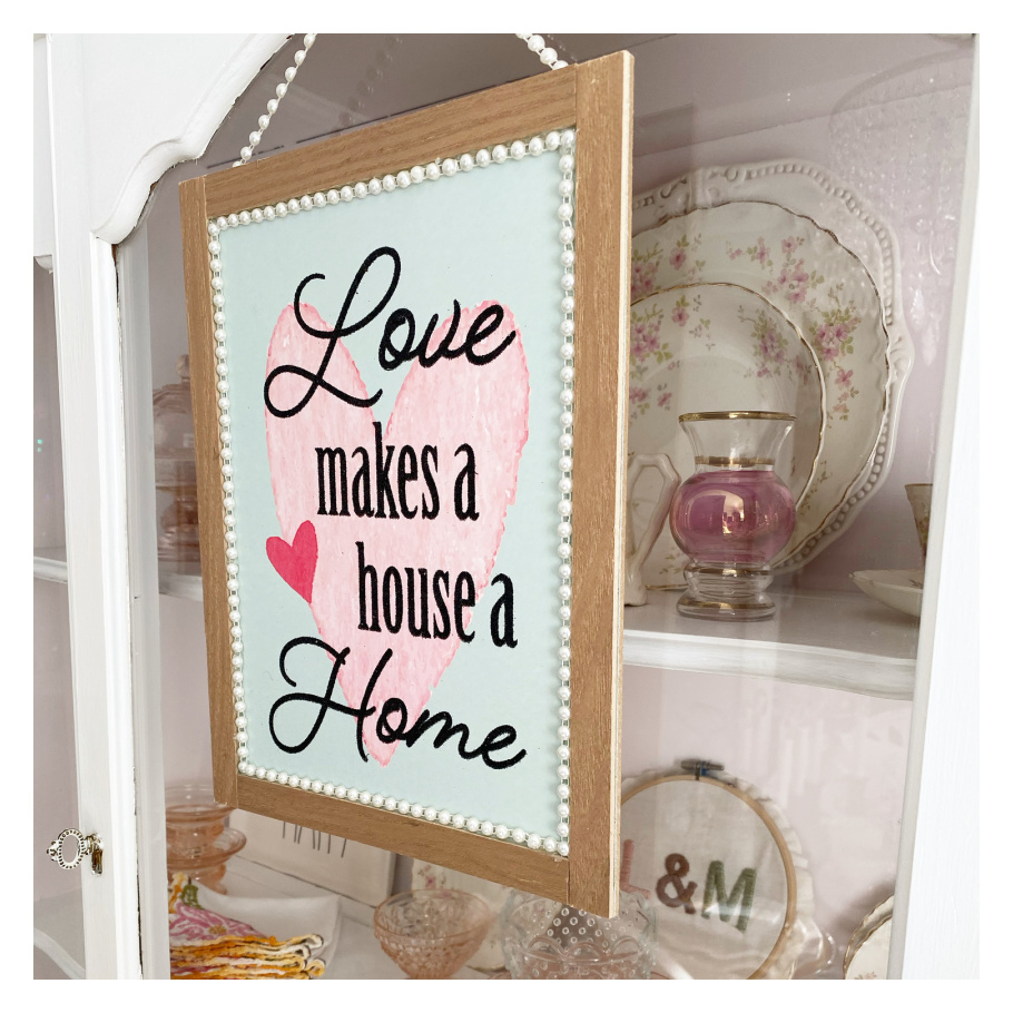 Pale pink and pale green Love make a house a home hanging on vintage china cabinet