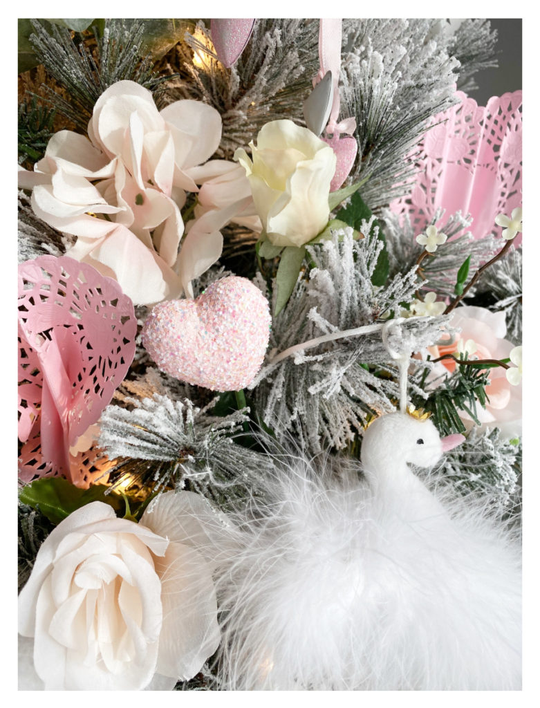 close up of valentine's day tree with pink glittered hearts and fluffy swans
