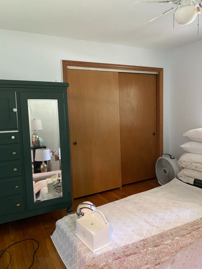 Antique hunter green armoire in guest room before makeover