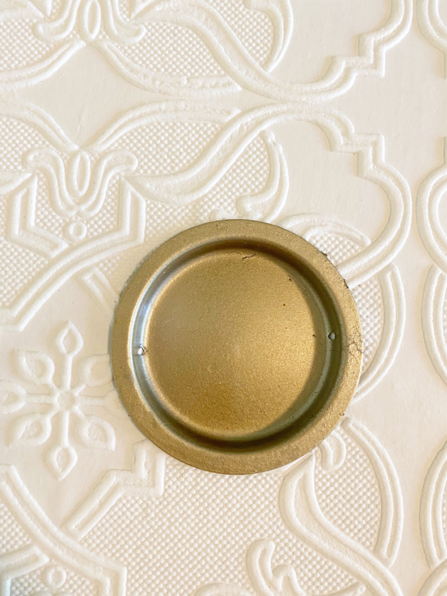 close up of wallpapered closet door and gold handle