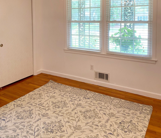 Pale blue and gray rug in guest room