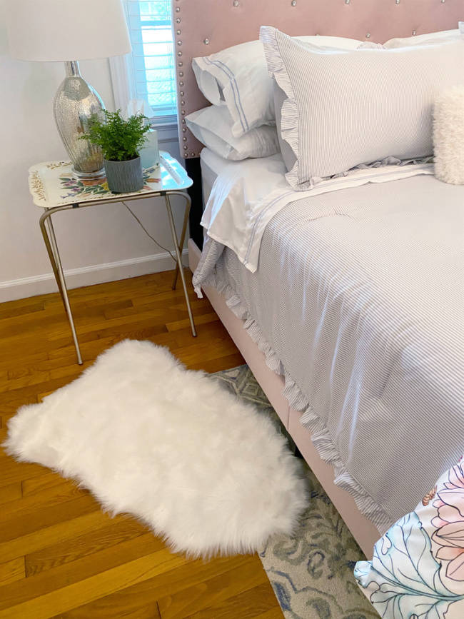 guest room bed and fluffy white rug beside bed