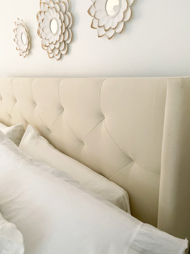 cream colored headboard in master bedroom