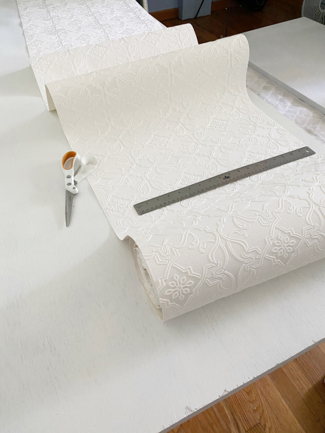 Unrolled wallpaper with scissors and ruler