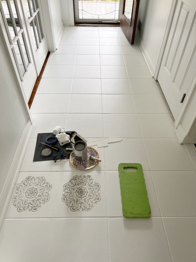 Starting to stencil the white painted foyer tiles