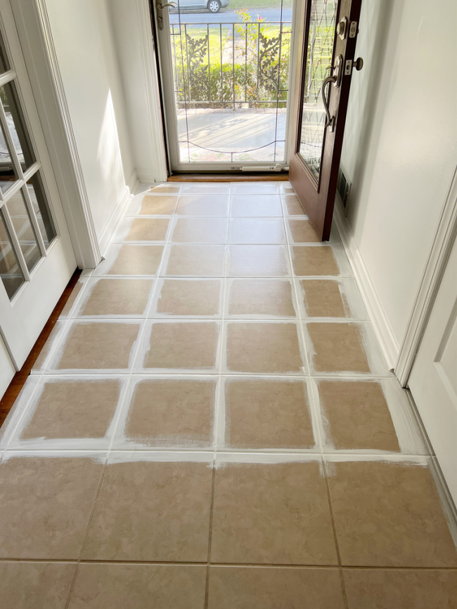 beige foyer tiles with white paint at edges and in grout lines