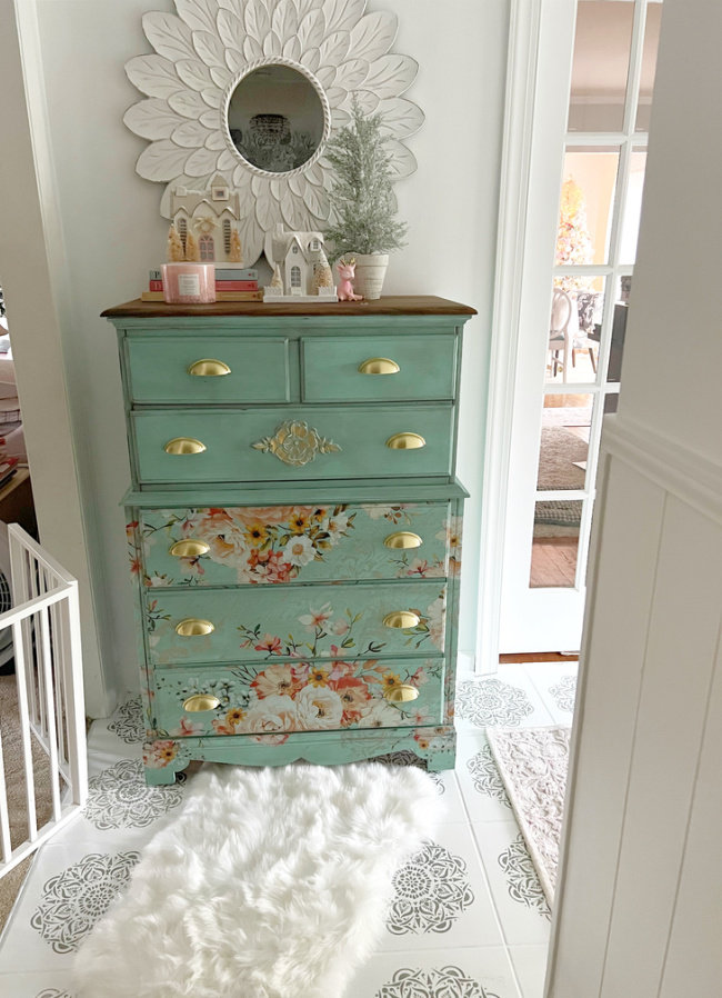 View of pretty floral dresser with fluffy white rug in front of it