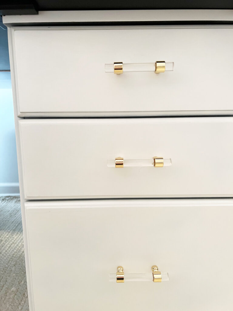 close up of white file cabinet with acrylic and gold drawer pulls